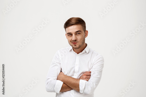 Successful businessman thinking, posing with crossed arms over white background.