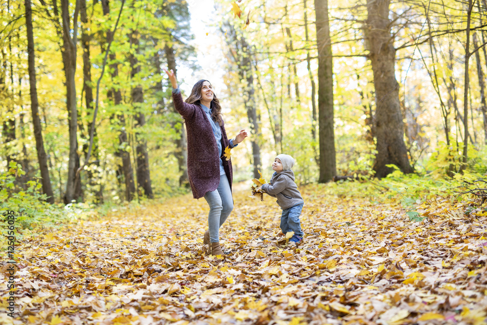 Mother with son in forest in autumn