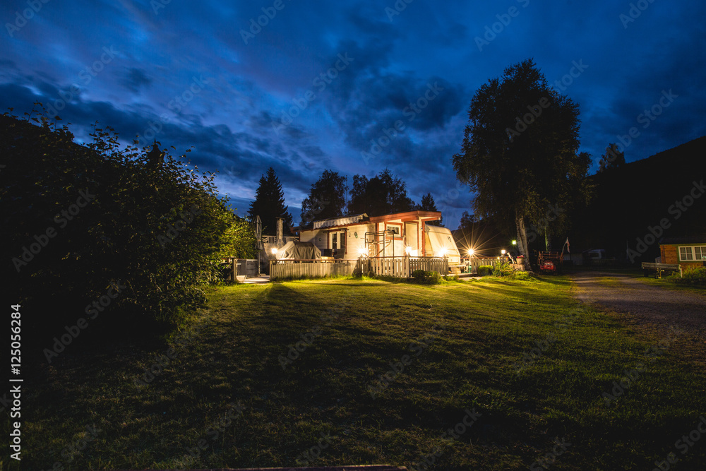 Norway camp house in the summer night. Blue sky. Adventure trip to norway.