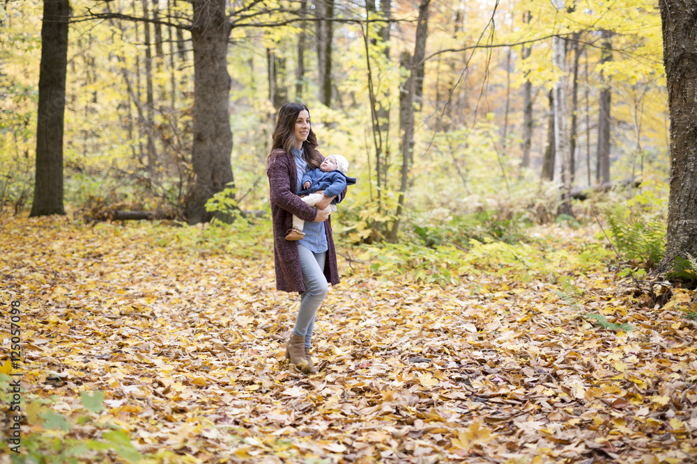 Mother with daughter baby in autumn forest