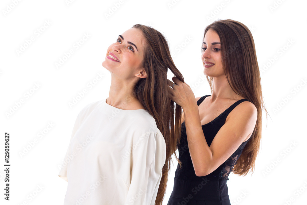 One woman making another one a plait One woman making another one a plait