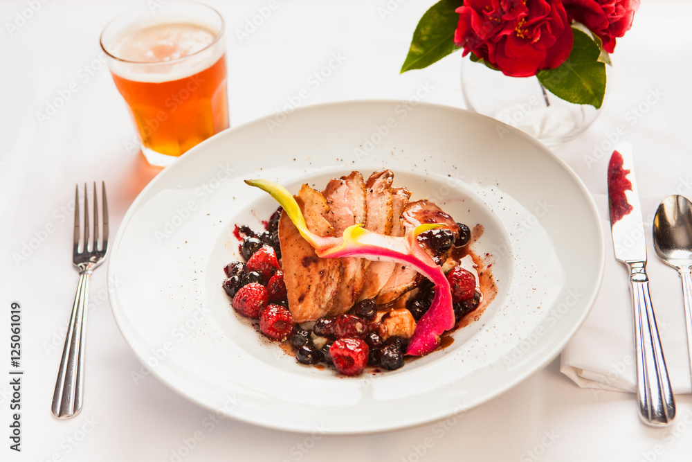 roasted pork with berry sauce and a glass of beer