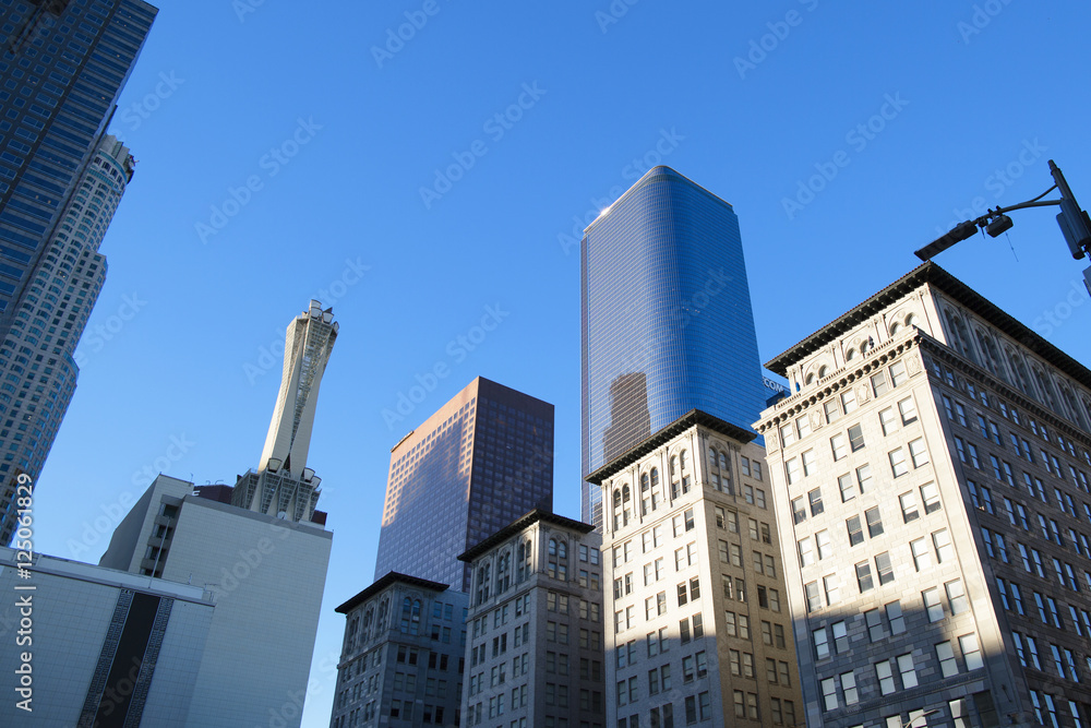 Obraz premium Skyscraper is on the blue sky background. High building is in Los Angeles, the downtown.