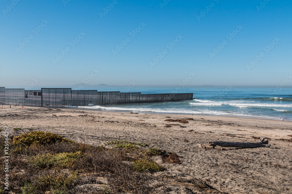 Border Field State Park beach with the international border wall separating San Diego, California and Tijuana, Mexico in the distance.