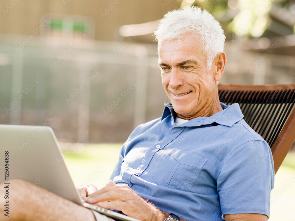 Senior man with notebook sitting in the park Senior man with notebook sitting in the park