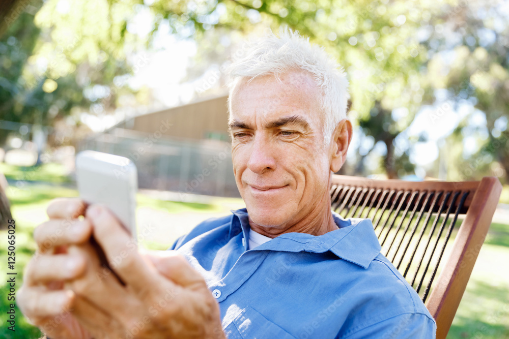 LoMature man outdoors using mobile phone LoMature man outdoors using mobile phone