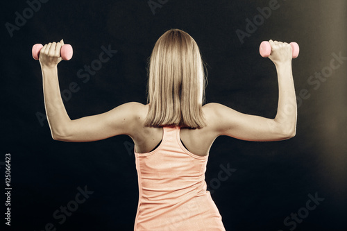 Fitness sporty girl lifting weights back view