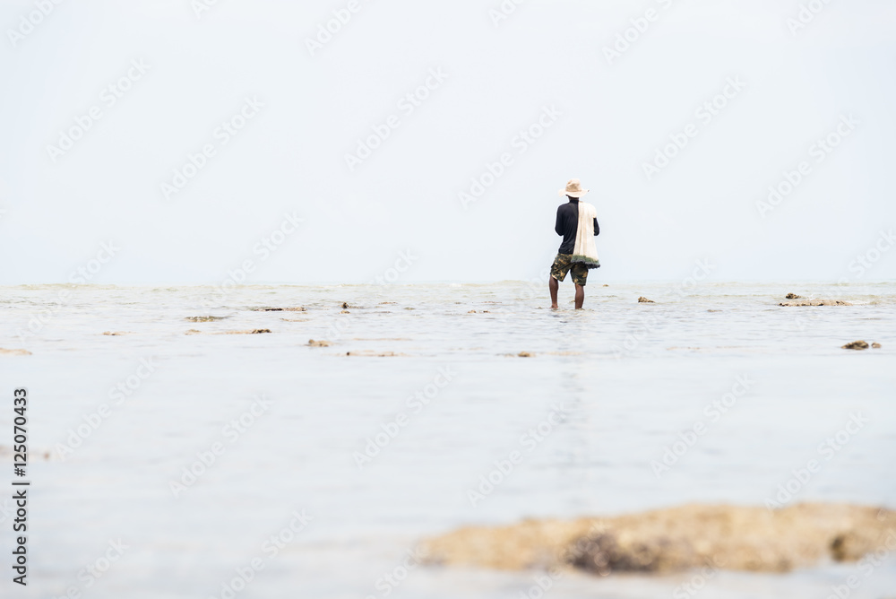 Fisherman on the beach in action when fishing Fisherman on the beach in action when fishing