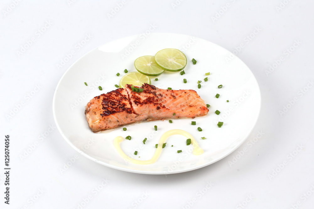Grilled salmon topped minced shallot ,mayonnaise and sliced lemon on white dish. Isolated. Grilled salmon topped minced shallot ,mayonnaise and sliced lemon on white dish. Isolated.