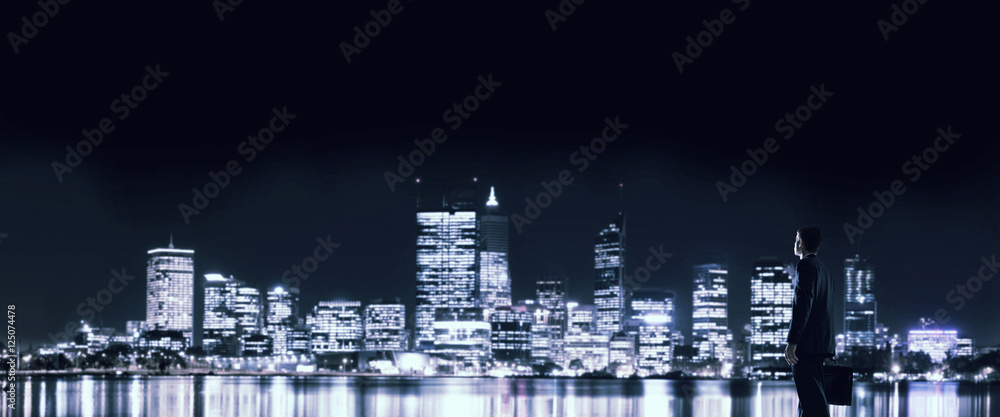 Businessman viewing night glowing city Businessman viewing night glowing city