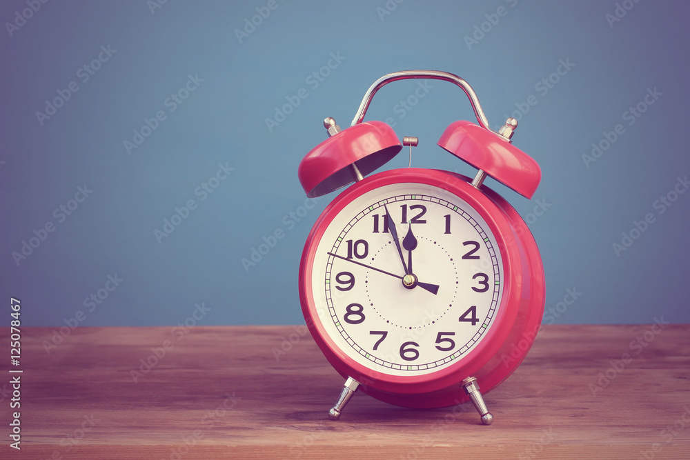 Red retro alarm clock at twelve o'clock. Red retro alarm clock at twelve o'clock.