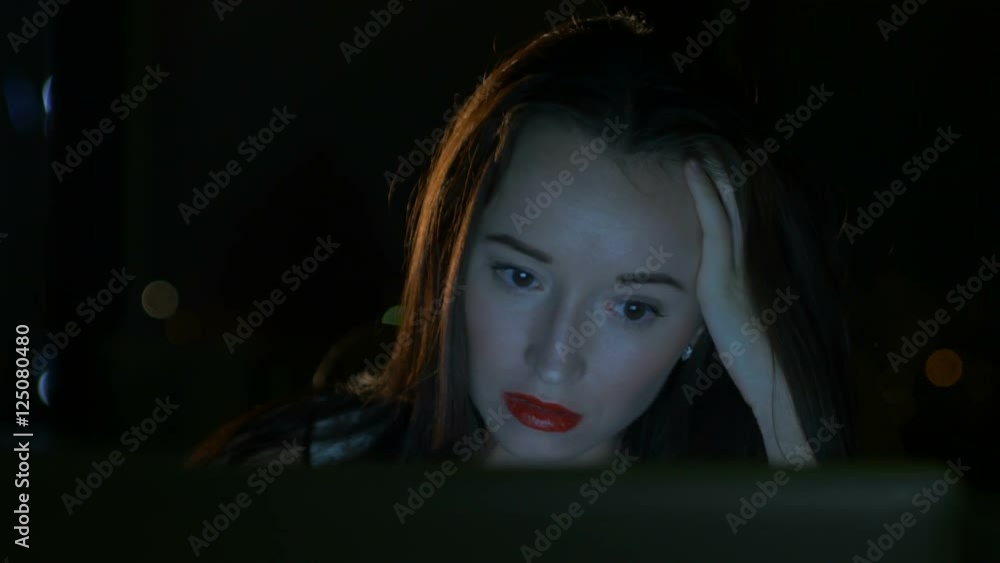 The girl looks in the laptop monitor The girl looks in the laptop monitor