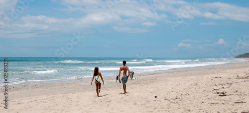 Couple de surfeur de dos sur la glage du pacifique 