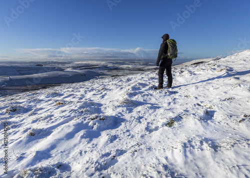 Hiker on Mam Tor in the Peak District in the winter snow