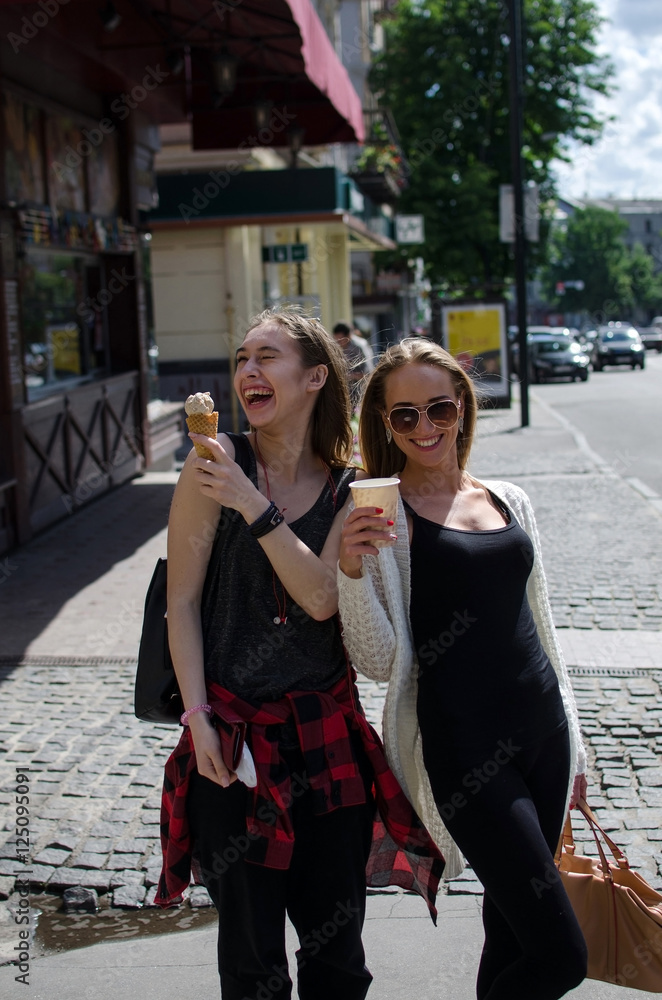 Fototapeta premium Two girlfriends are eating icecream