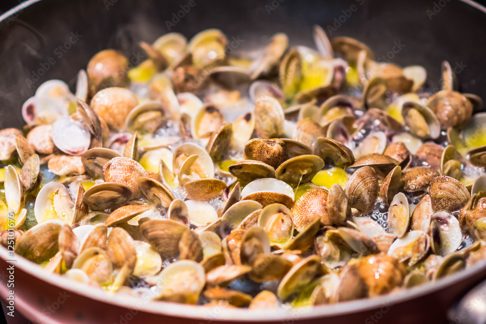 Cooking clams in a pan, Italian food tradition Cooking clams in a pan, Italian food tradition
