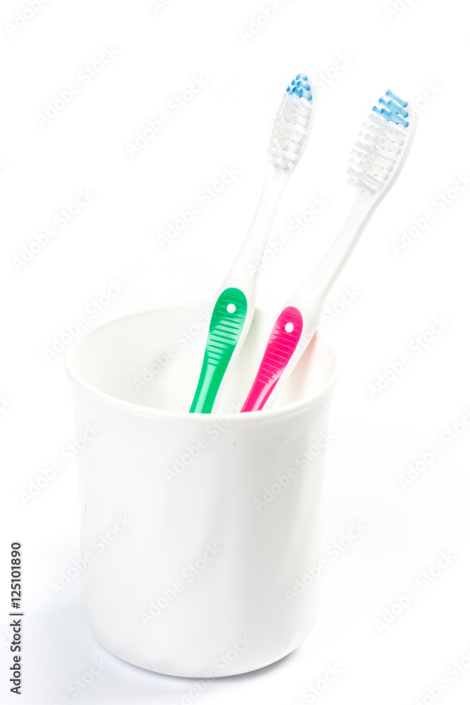 Toothbrushes in glass on table on light background Toothbrushes in glass on table on light background
