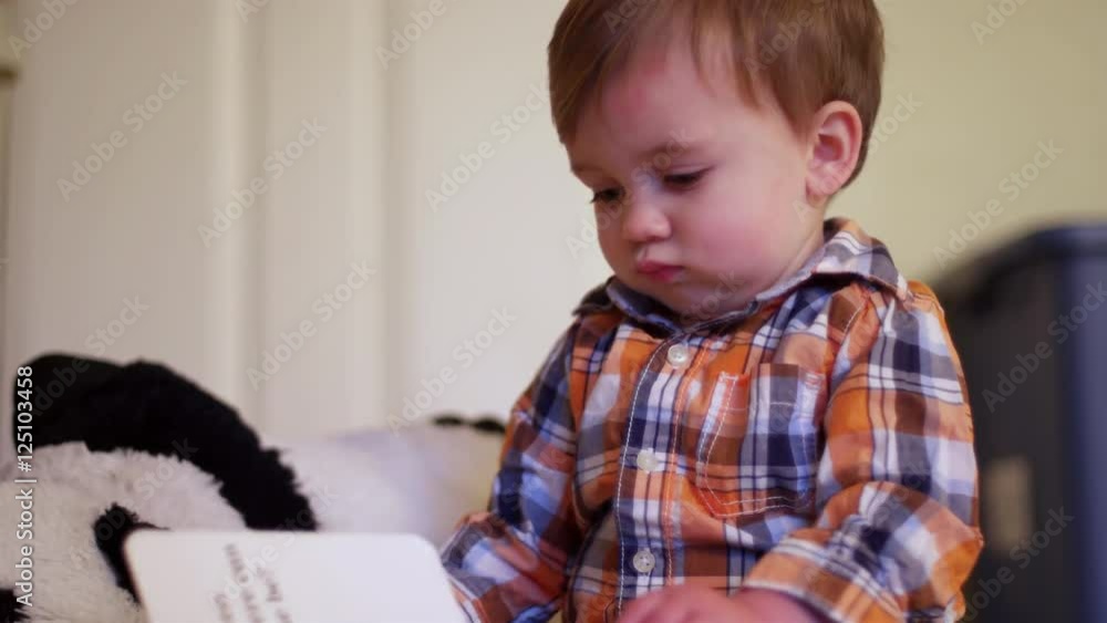 A little boy sitting on the floor reading a book A little boy sitting on the floor reading a book