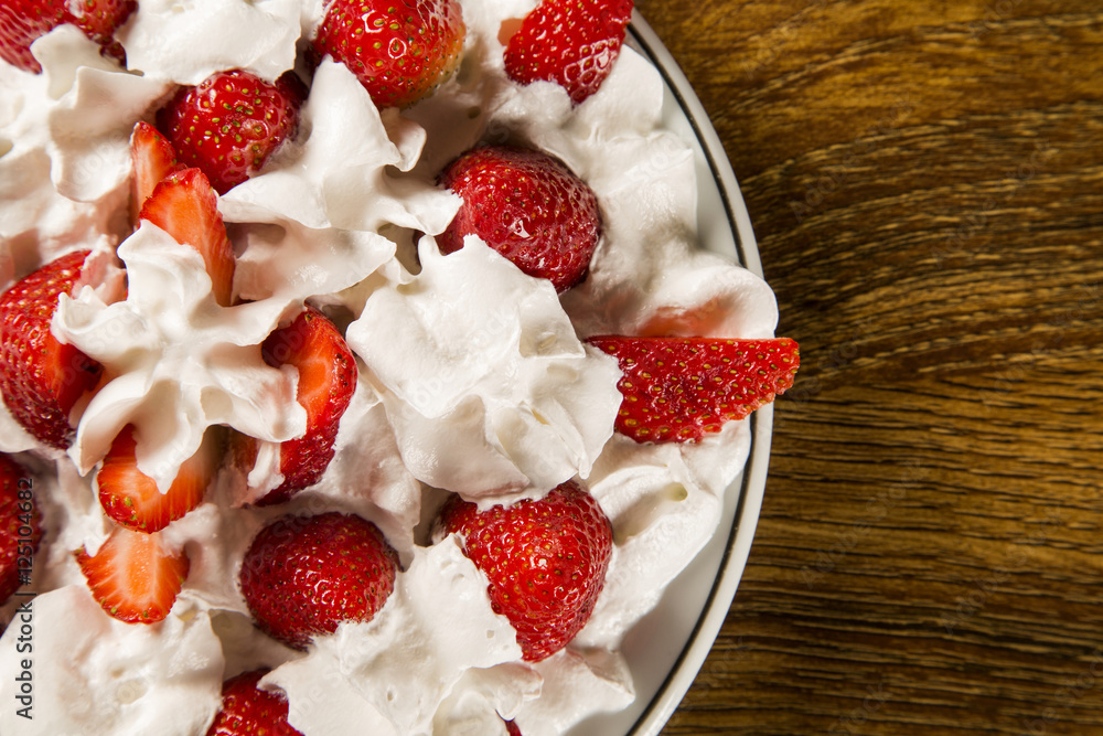 Strawberry with chantilly cream in a dish on a wooden table Strawberry with chantilly cream in a dish on a wooden table