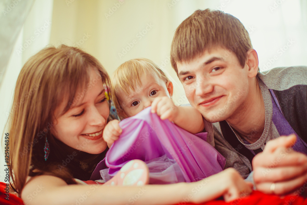 Girl raises her violet skirt up while lying between her parents Girl raises her violet skirt up while lying between her parents