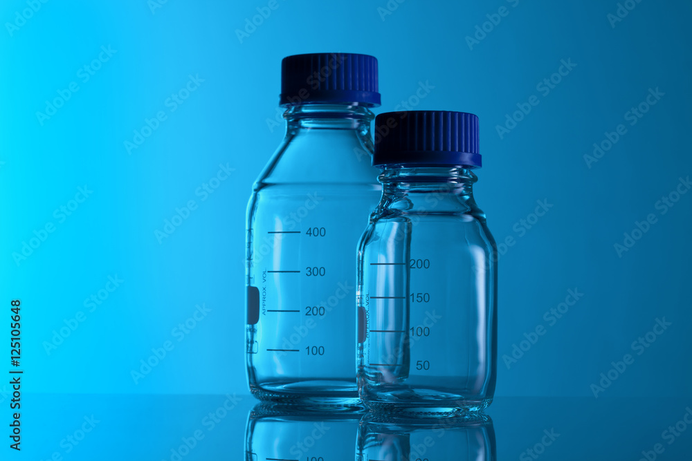 Labotatory test glass container on a blue background Labotatory test glass container on a blue background