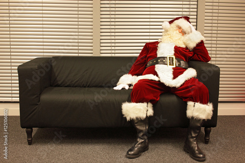 Obraz na plátne waiting for christmas job, santa claus sleeping on sofa in office