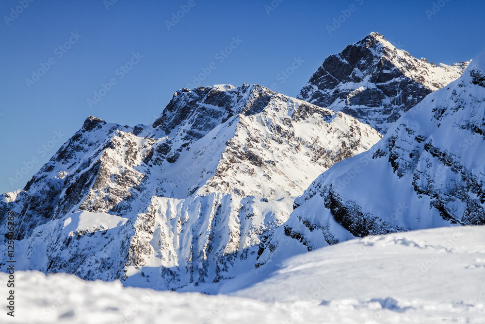 Snowy Agepsta peak winter mountain landscape on blue sky background