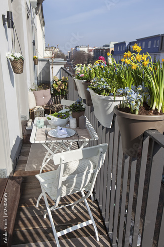 potted spring flowers on a sunny balcony