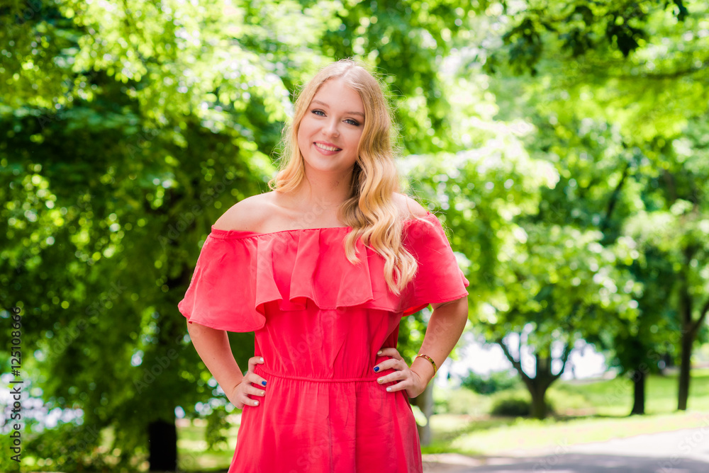 Fototapeta premium Young smiling blonde woman outdoors portrait. Soft sunny colors.Close portrait.