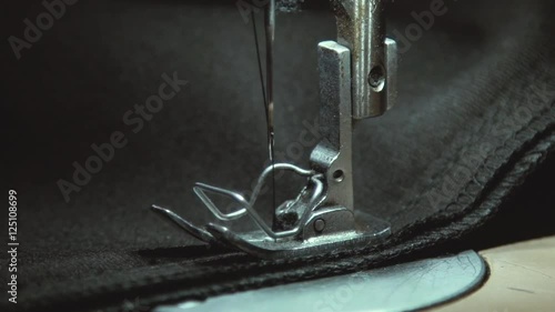 Wallpaper Mural Macro. Panning on steel sewing needle in slow motion. Part of modern sewing machine isolated on black background. A hand of a dressmaker supporting a cloth while sewing on a sewing machine. Sewing. Torontodigital.ca