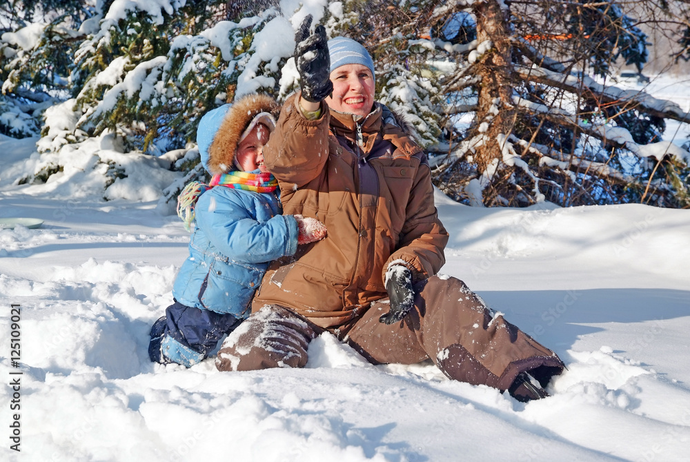 Obraz premium happy family of mother with kid playing in the snow winter park