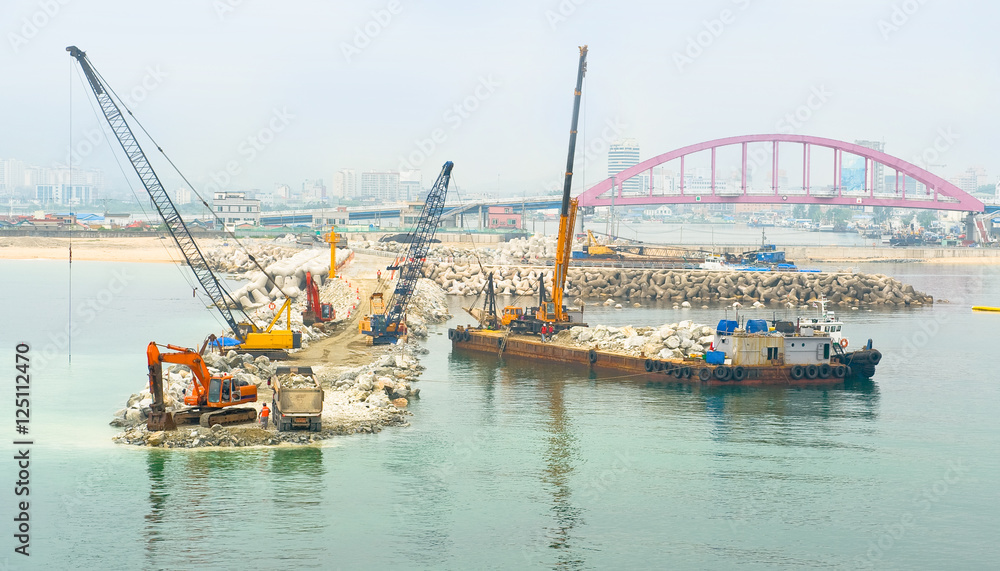 cranes and excavator machines in a pier construction site at Sok