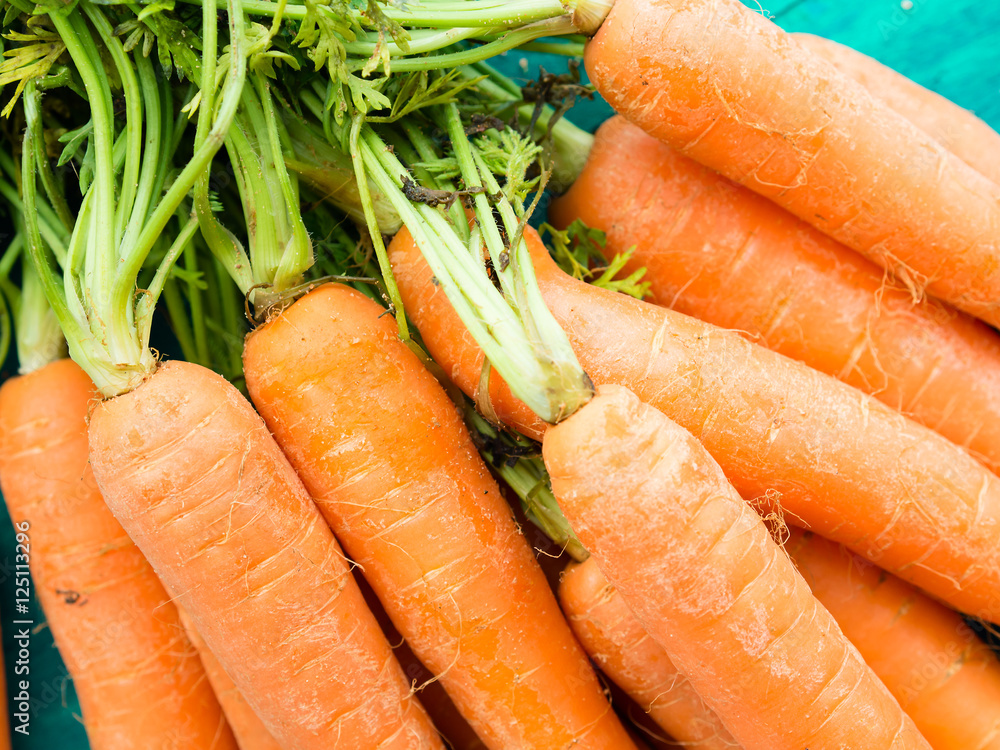 Bunch of carrots on green background. Top view Bunch of carrots on green background. Top view