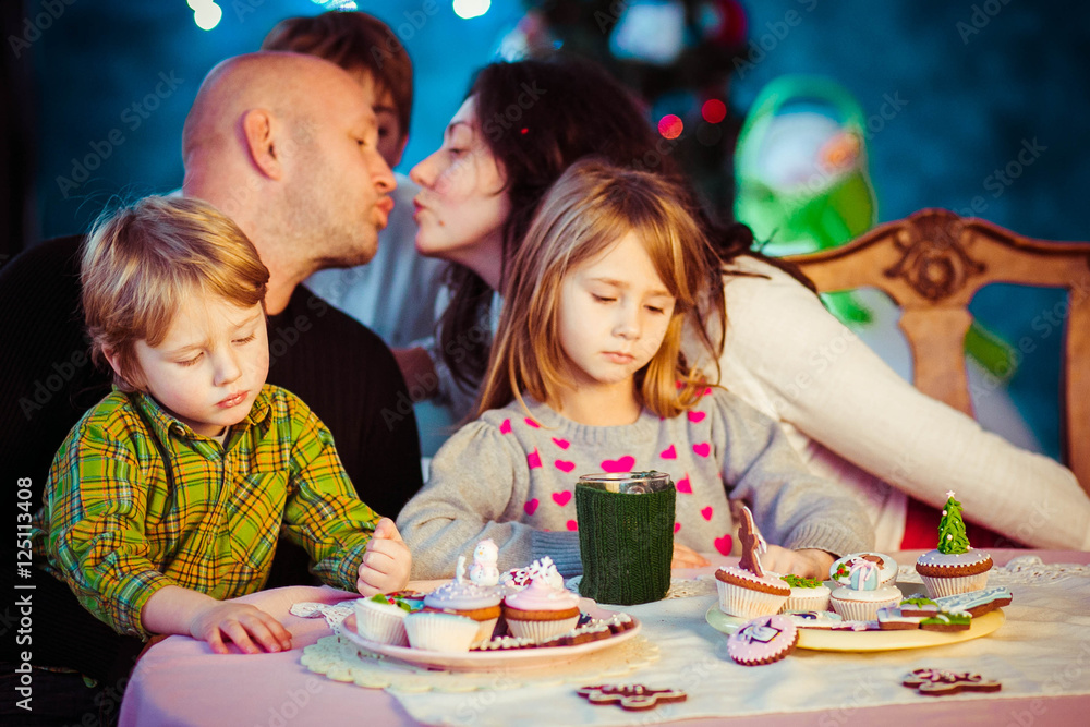 Fototapeta premium happy and beautiful family sitting together at the table
