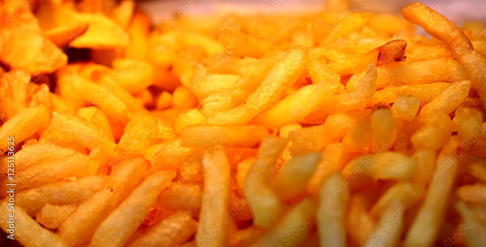 Large pan of fresh cooked sweet potato fries, fresh out of frying oil yellow colorful close up patterns Large pan of fresh cooked sweet potato fries, fresh out of frying oil yellow colorful close up patterns