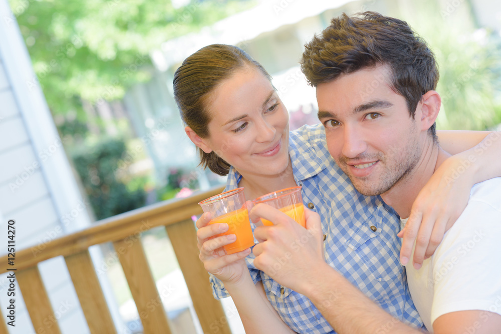 Amorous couple with glasses of juice Amorous couple with glasses of juice