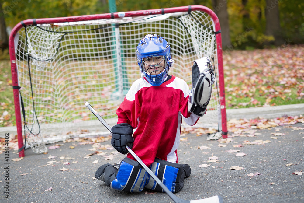 boy dressed to be the goalie in a street hockey game foto de Stock