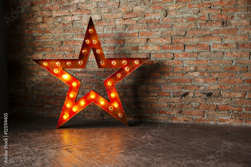 Decorative star with lamps on a background of brick wall. Modern grungy interior