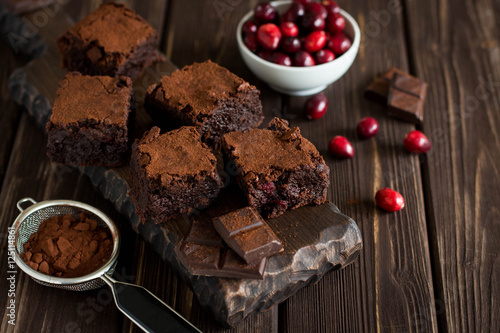 Canvas Print Dark chocolate brownies with cranberries on rustic wooden background