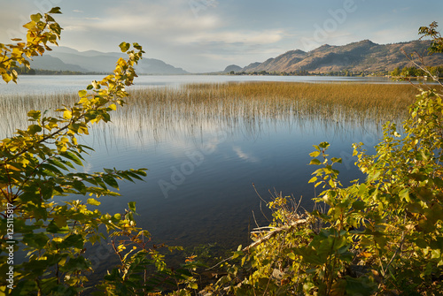 Sunrise Osoyoos Lake, British Columbia. A quiet morning on Osoyoos Lake, British Columbia, Canada. The first light of the morning lights up the sky and reflects in the still lake.
 photo