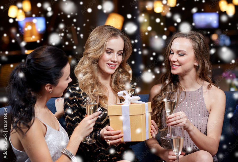 happy women with champagne and gift at night club happy women with champagne and gift at night club
