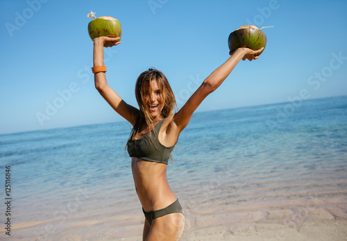 Happy young woman on the beach with fresh coconuts © Jacob Lund
