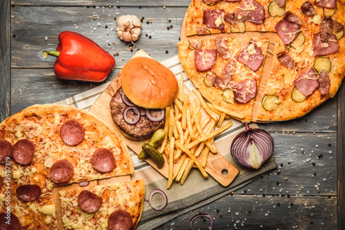 pizza and hamburger on wooden background