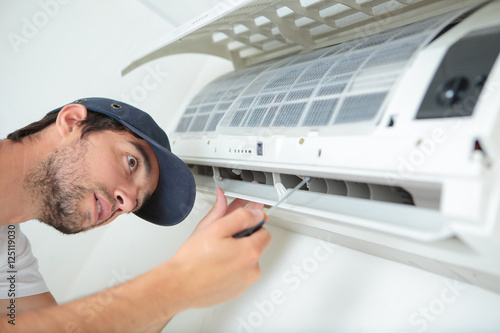 Man working on air conditioning unit photo