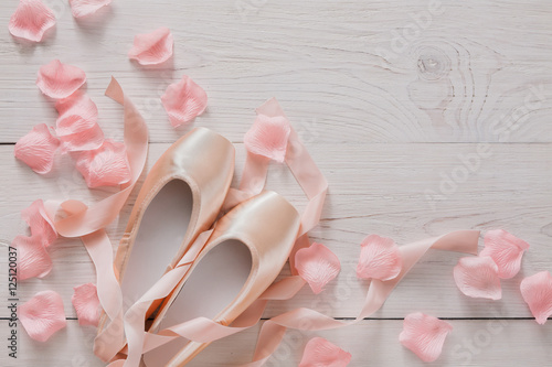 Pink ballet pointe shoes on white wood background