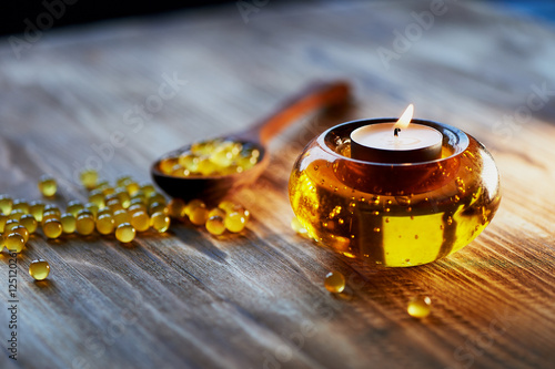 Candle in glass orange candle holder with colorful beads, seduta. Smoke rises