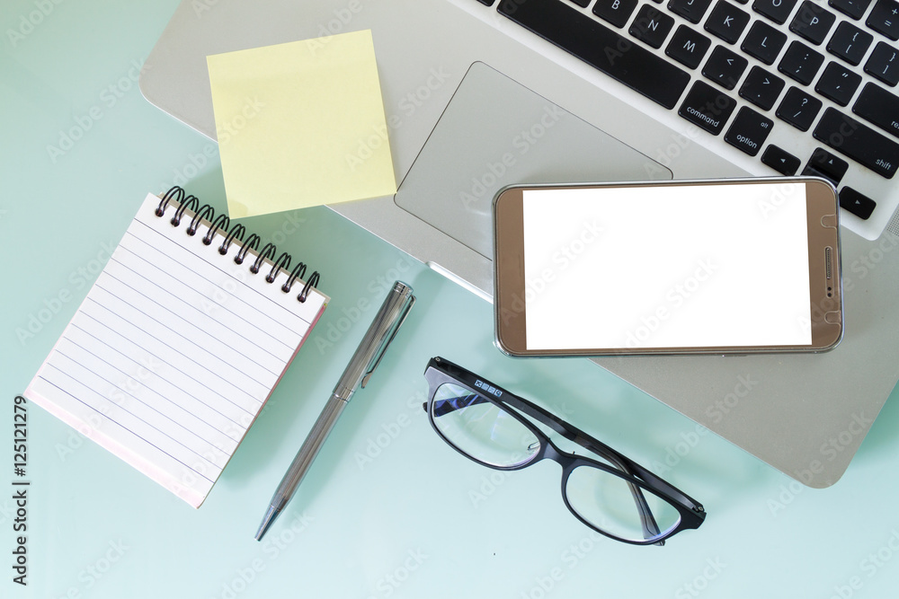Top view of working area, laptop, smartphone, glasses and empty note, business work desk Top view of working area, laptop, smartphone, glasses and empty note, business work desk