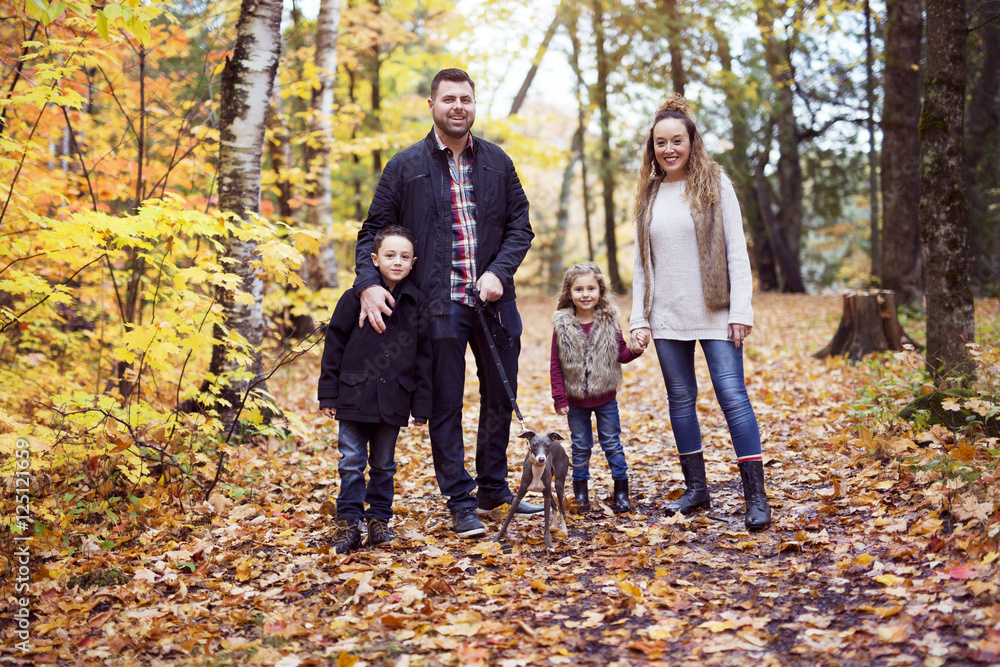 Family of four enjoying golden leaves in autumn park Family of four enjoying golden leaves in autumn park