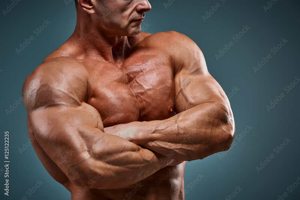 torso of attractive male body builder on gray background. Stock Photo