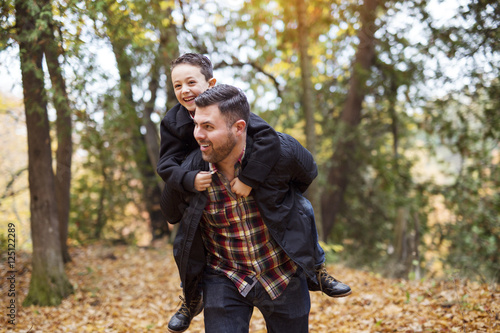 father and son having fun in autumn park